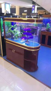 Aquarium showcase featuring vibrant aquatic plants and colorful lighting in a shopping mall setting.